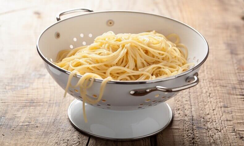 How can you prevent pasta from sticking to the colander?